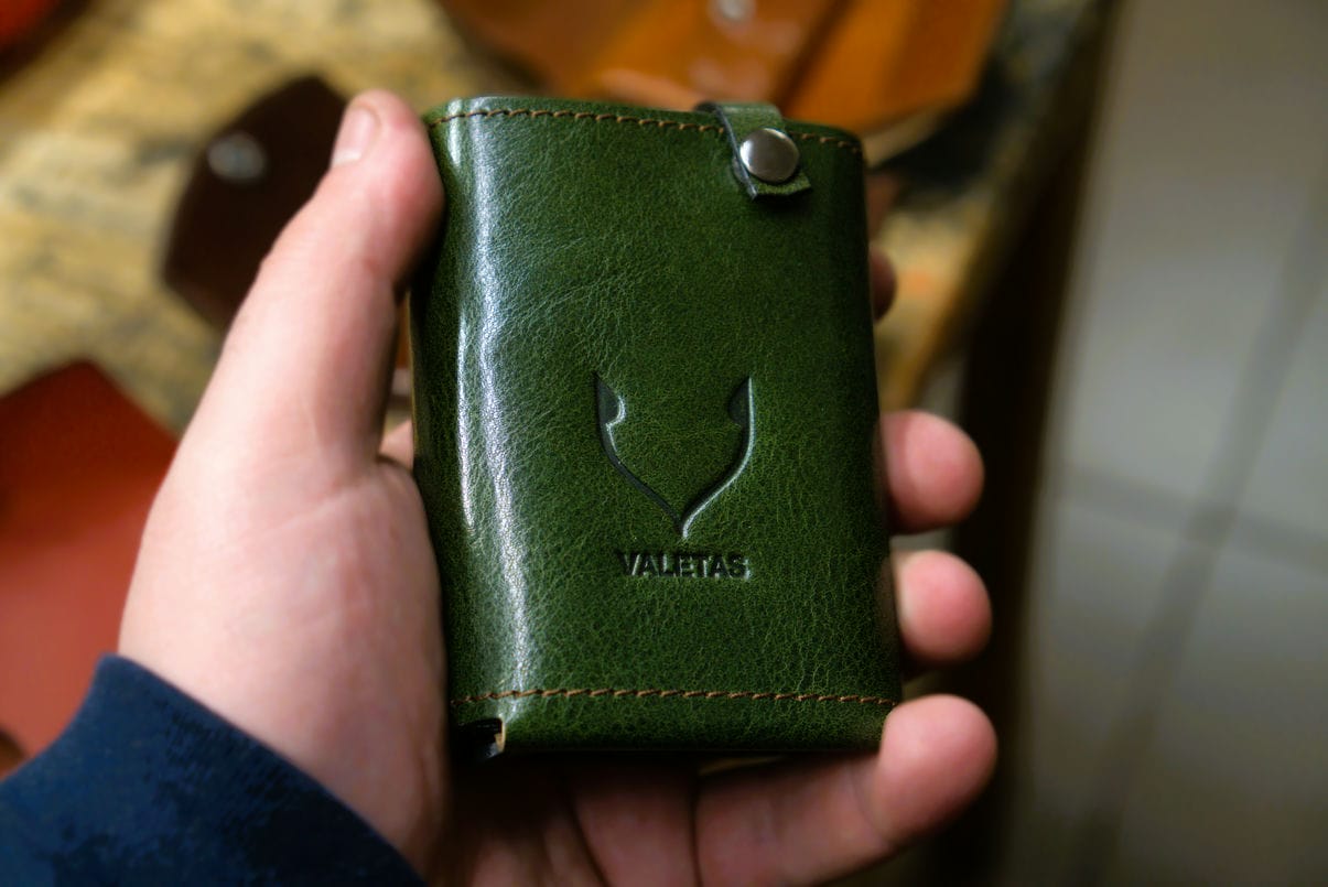 Zielony portfel skórzany Valetas V3 Plius Exclusive trzymany w dłoni – kompaktowy i elegancki